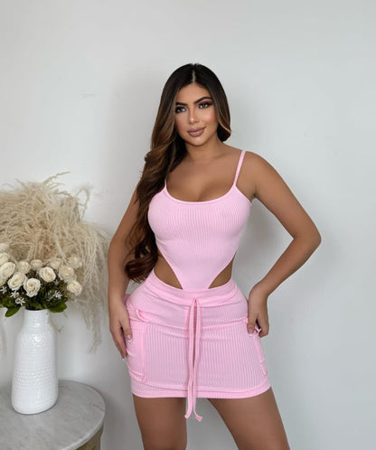Mujer con conjunto de body y falda rosa de canalé, look de moda femenina casual.