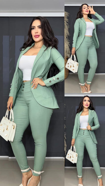 Mujer con conjunto de ropa formal verde menta, blazer, pantalón ajustado y top blanco, bolso blanco elegante.