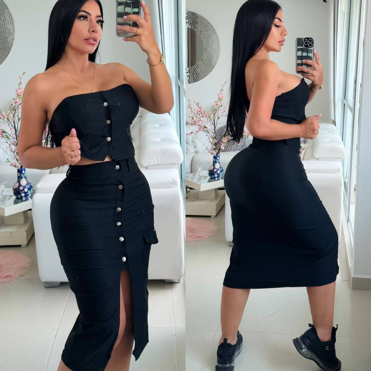 Mujer con conjunto de falda y top negro, ajustado, con botones, en sala moderna.